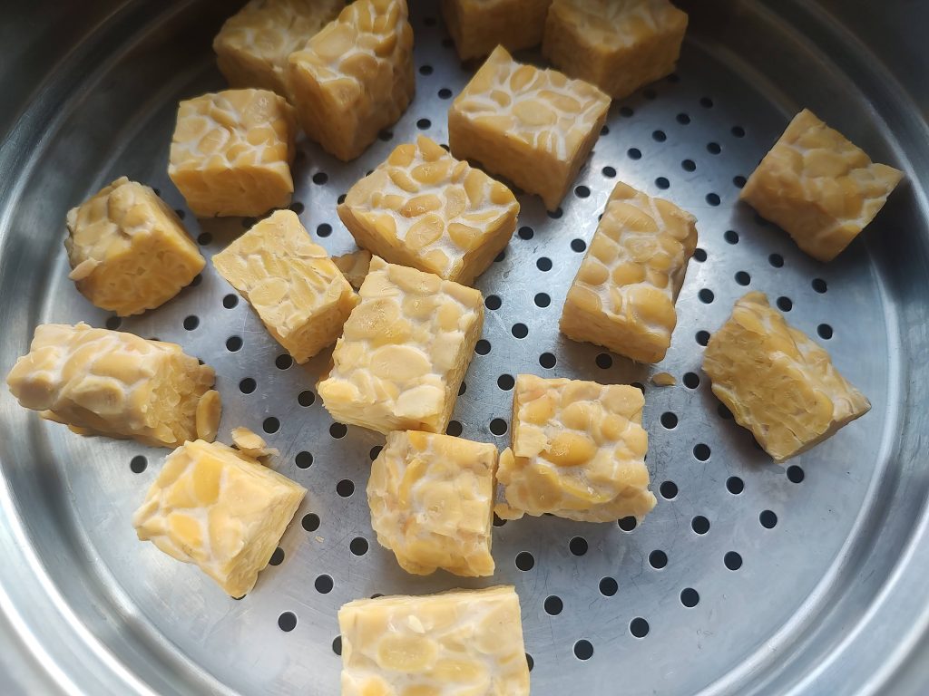 Cubed tempeh in a steamer basket.