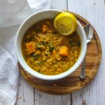 Red lentil soup in a white bowl.
