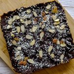 Chocolate Almond Coconut bars on a wooden tray'